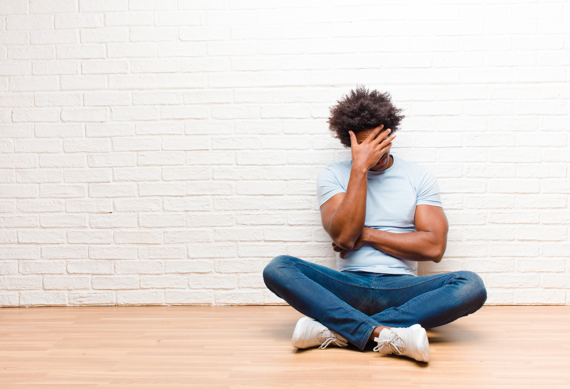 Man covering face suffering from addiction